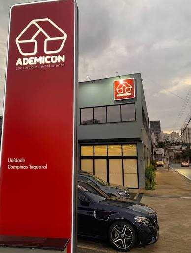Fachada de uma loja Ademicon em Campinas, com o totem vermelho da marca na entrada
